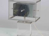 a clock that is in a glass box on a stand