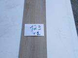 Deux morceaux de bois sont posés sur une table, accompagnés d'une étiquette indiquant leur prix.