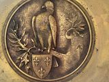a metal plate with a bird and shield on it