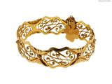 gros plan d'un bracelet en or sur fond blanc