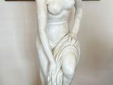 une statue représentant une femme assise sur un socle