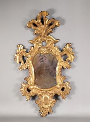 un miroir doré dans lequel se reflète l'image d'un homme