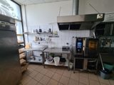 a kitchen with a refrigerator, stove, sink, and other appliances