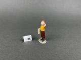 figurine of a man holding a sign with a number in front of him