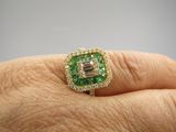 un gros plan sur la main d'une personne tenant une bague verte et blanche