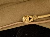 a brown hat with a gold clasp on it