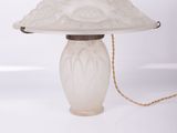une lampe de table blanche surmontée d'un abat-jour en verre