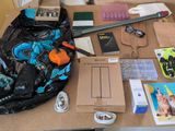 a table with a bag, a backpack, a cell phone, and other items on it