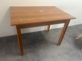 a small wooden table with a laptop on top of it