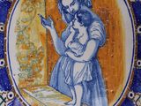 a blue and white plate with a picture of a woman holding a child