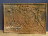 une vieille plaque métallique sur laquelle figure un blason