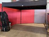 une tente située dans un bâtiment, avec un mur rouge en arrière-plan