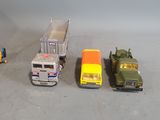 several toy trucks are lined up in a row on a gray surface