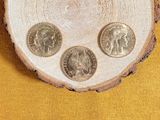 three coins sitting on top of a piece of wood