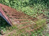 an old rusted metal fence sitting in the middle of a garden