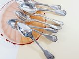 several silver spoons and spoon spoons on a plate on a table