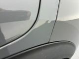 a close up of a car ' s door handle with a reflection of a man in the background