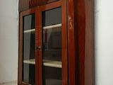 an old wooden cabinet with glass doors on it