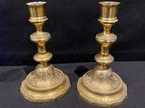pair of antique brass candlesticks on a black background