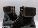 pair of black boots with brown trims on a white background