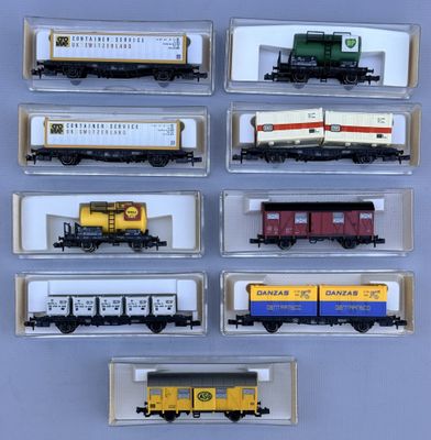 several model train cars are lined up in a display case