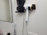 a hair dryer that is on the wall above a sink