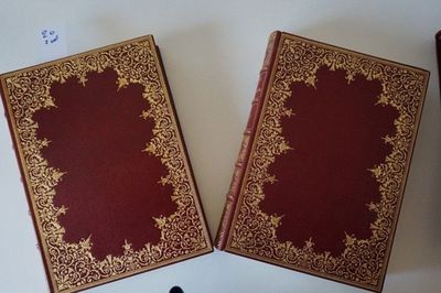 two old books sitting on a table next to each other