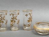 five glasses and a pitcher sitting next to each other