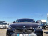 the front of a black bmw car parked in a parking lot