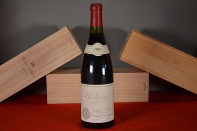 a bottle of wine sitting on a table next to two wooden boxes