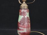 an old fashioned lamp with a red and green design on it
