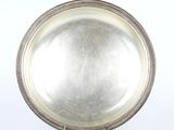 assiette en argent plaqué avec bord perlé, posée sur un support, sur fond blanc