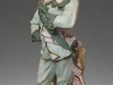figurine of a boy holding a bird on a rock