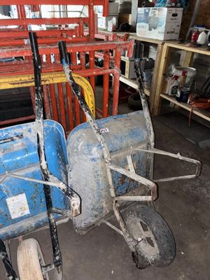 un petit tracteur bleu et une remorque bleue dans un garage
