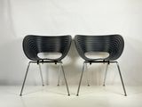 two black chairs sitting next to each other on a white floor