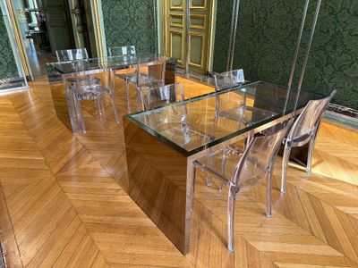 une table en verre avec des chaises et un miroir posé par terre