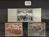 trois timbres exposés dans une vitrine posée sur un socle en bois