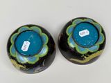 two black vases with blue and green designs on them