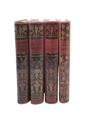 four books are lined up in a row on a white surface