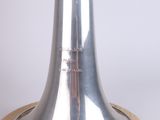 a silver vase with yellow flowers in it on a wooden stand