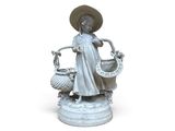 une statue représentant une femme tenant un panier de fleurs