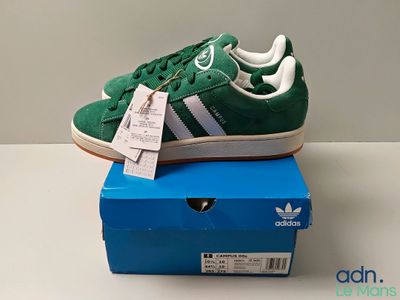 adidas superstar shoes in green and white on a blue box