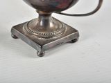 a silver vase that is sitting on a small stand