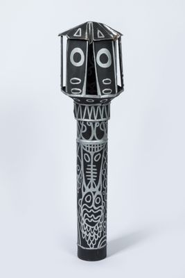 an image of a black and white sculpture of a bird on a pole