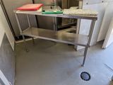 une table en acier inoxydable dans une cuisine équipée d'un évier