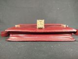 a red leather purse with a gold clasp on it