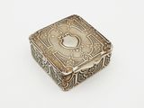 an antique silver box on a white surface with a white background