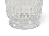 a clear glass cup with a silver lid on a white surface