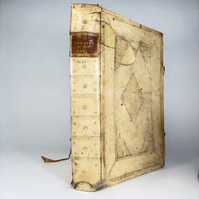 an old book sitting on top of a white table next to a lamp