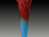 a red and blue vase sitting on a table